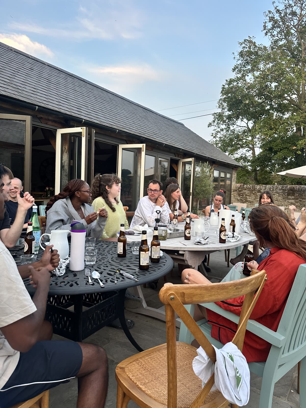 The team eating dinner around tables in a garden